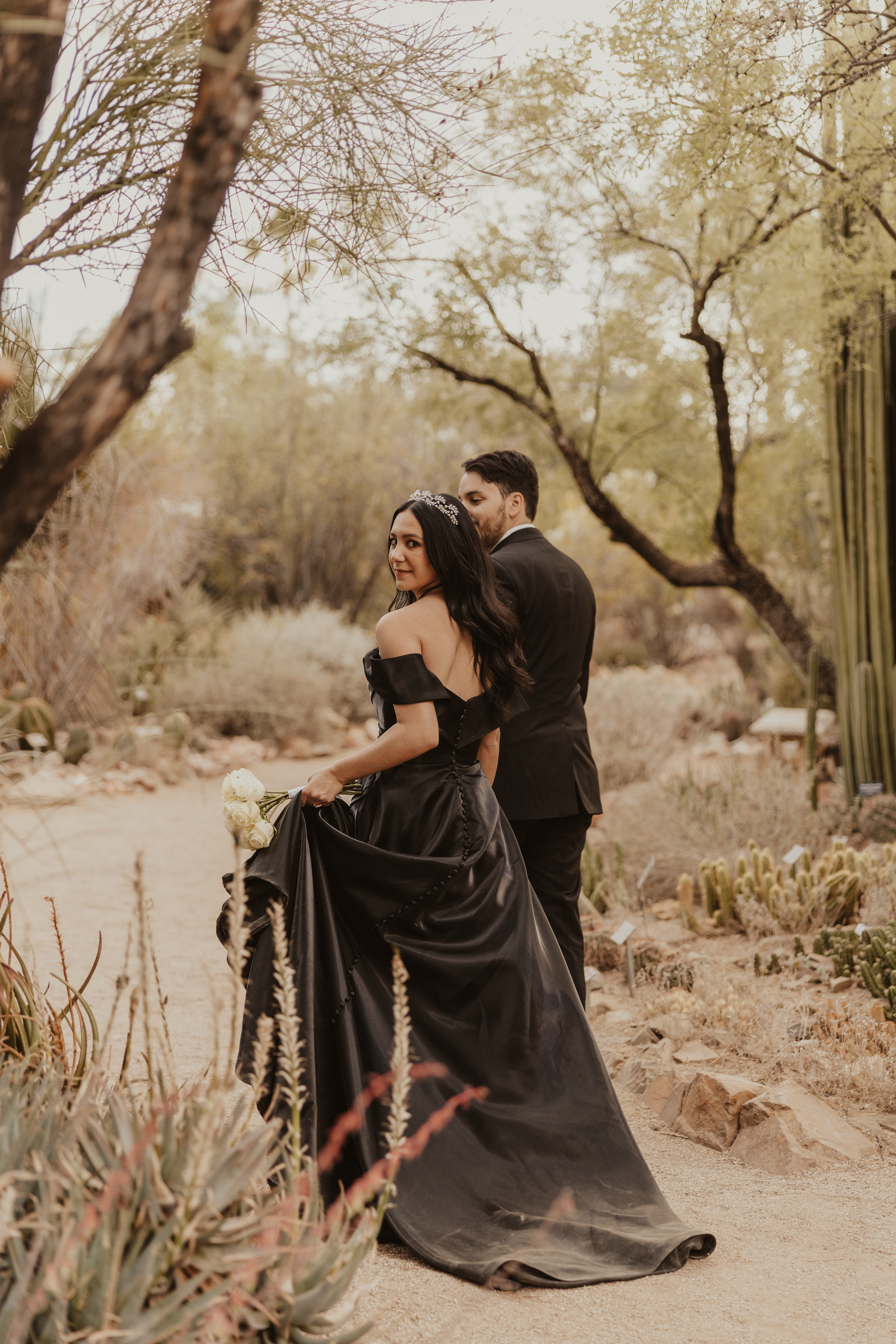 Tucson wedding planning featuring a bride and groom in a desert garden surrounded by cacti and desert plants.